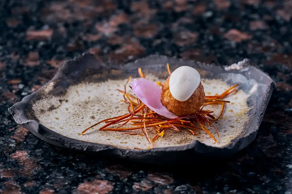 Chef preparing a refined dish at Evolution by Pikaia