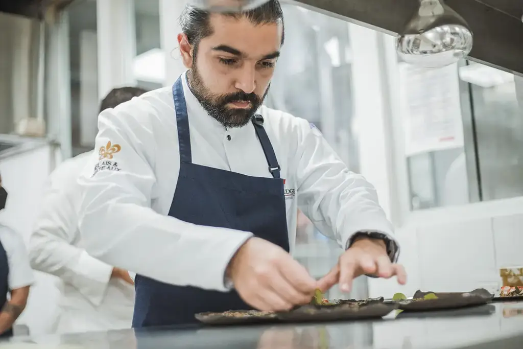 Chef plating a dish at Evolution by Pikaia