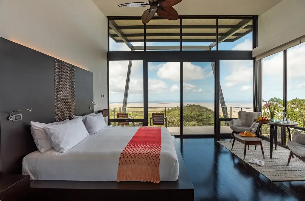 Suite bedroom at Pikaia Lodge overlooking the Galápagos landscape